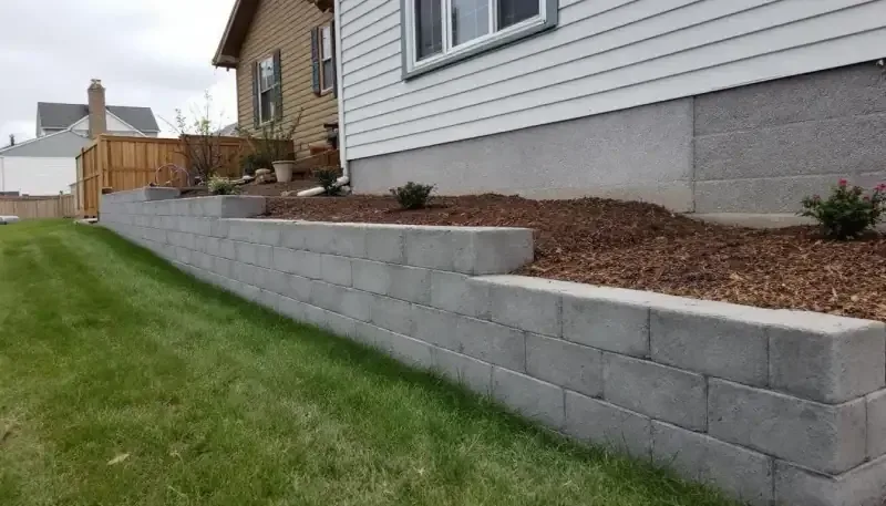 Concrete retaining wall with fence post brackets in Bonner Springs, KS
